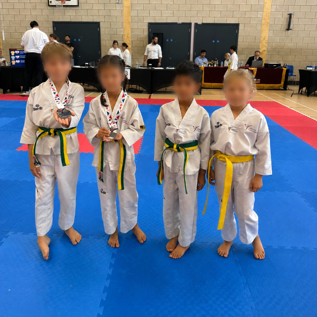 Four young students on the competition mat with medals