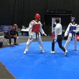 Cadets sparring in full kit with a referee